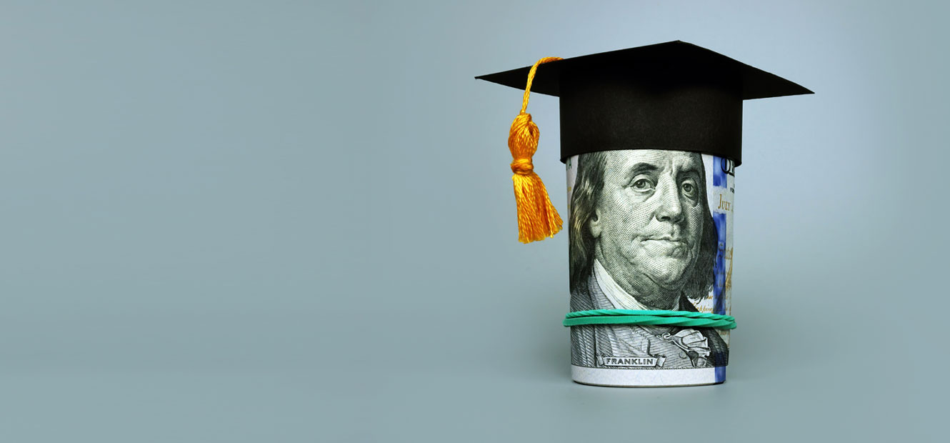 A rolled-up $100 bill is shown with Benjamin Franklin's face, wearing a paper graduation cap with tassel. 
